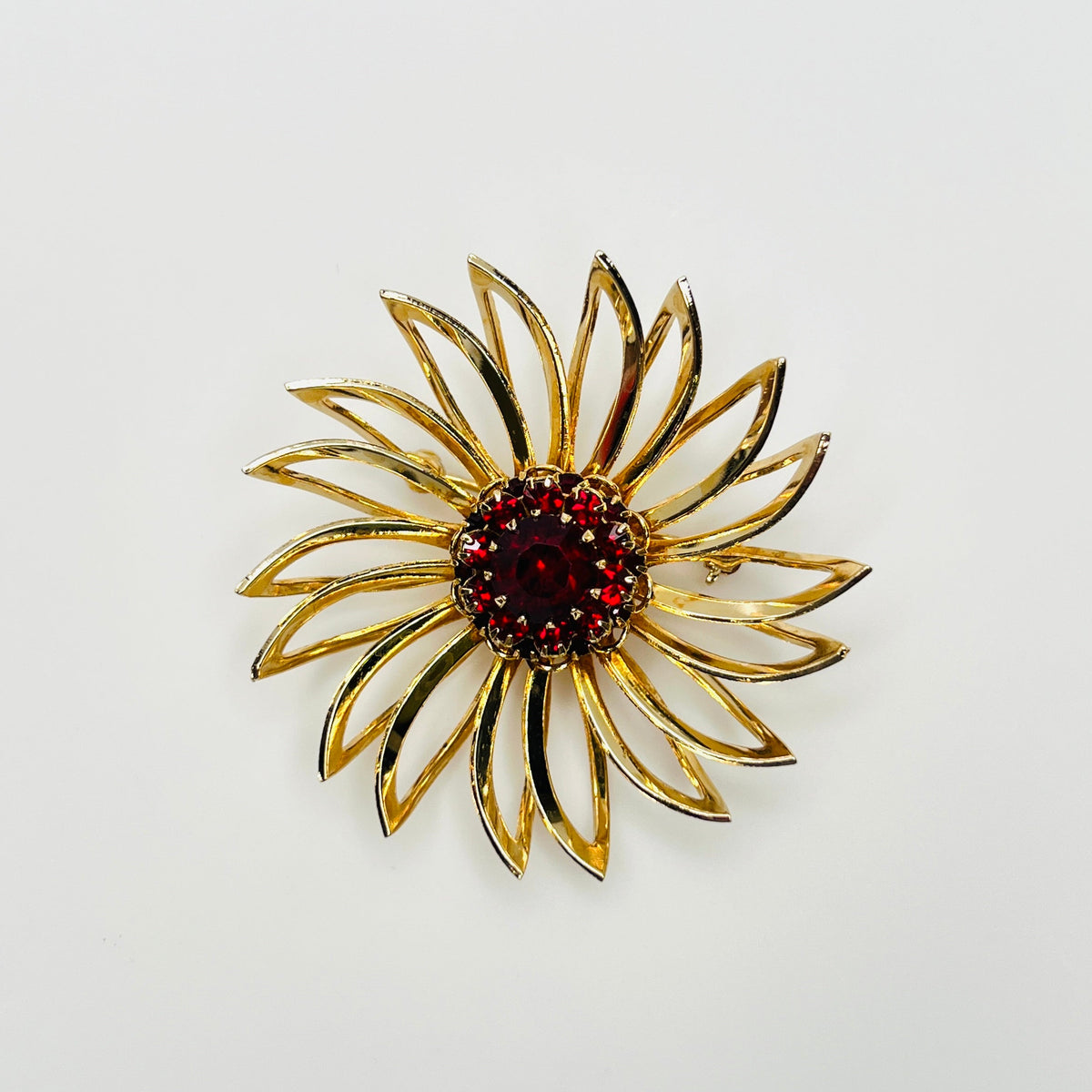 Vintage 1960s Sarah Coventry gold-tone flower brooch with ruby red rhinestone center