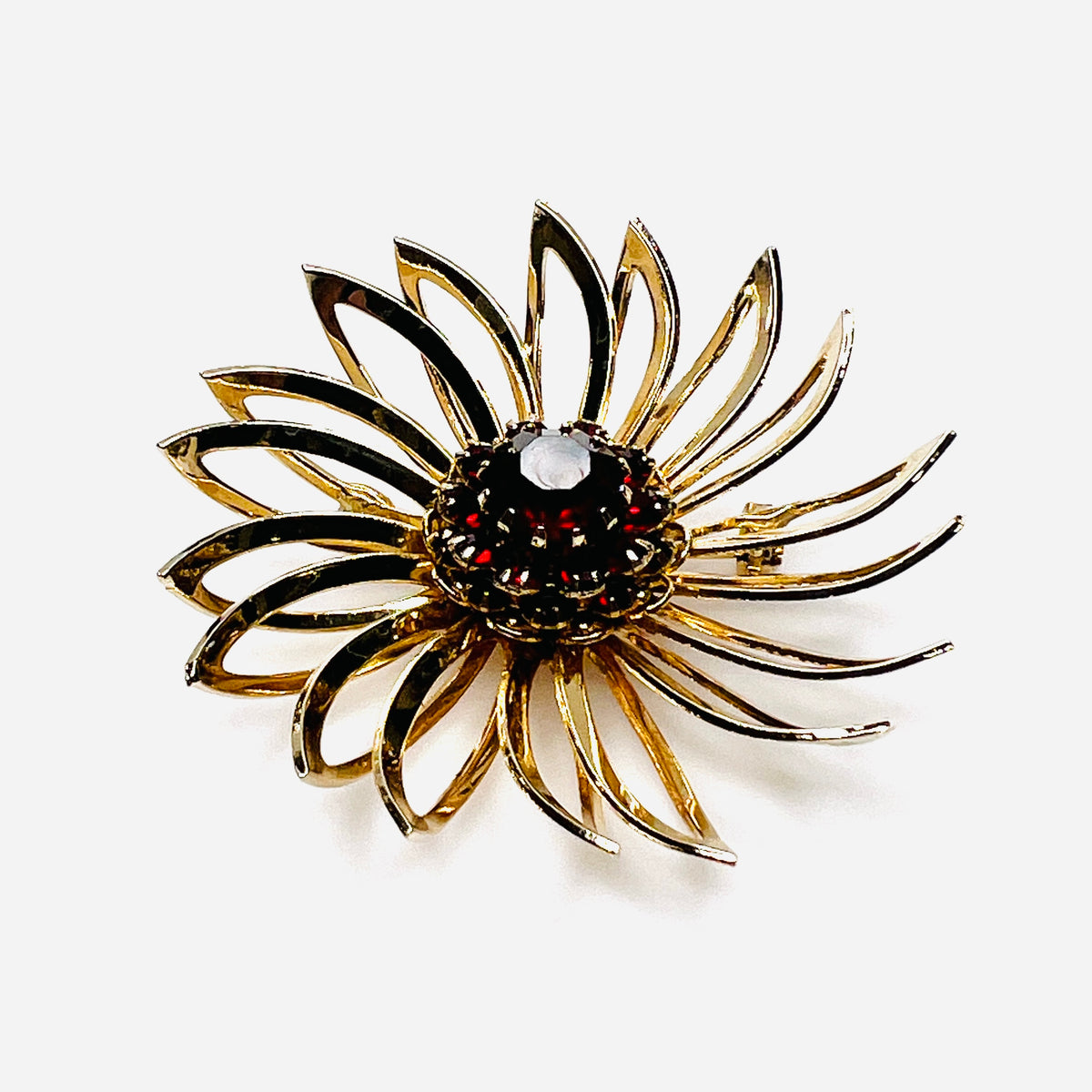 Side view of 1960s gold-tone flower brooch showing raised prong-set red rhinestones