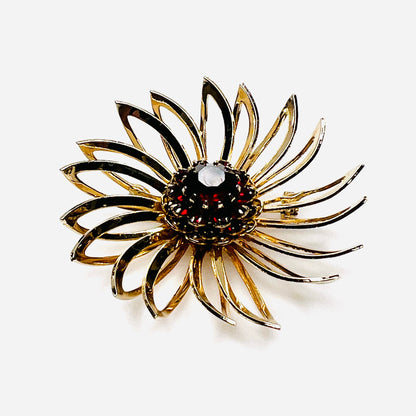 Side view of 1960s gold-tone flower brooch showing raised prong-set red rhinestones
