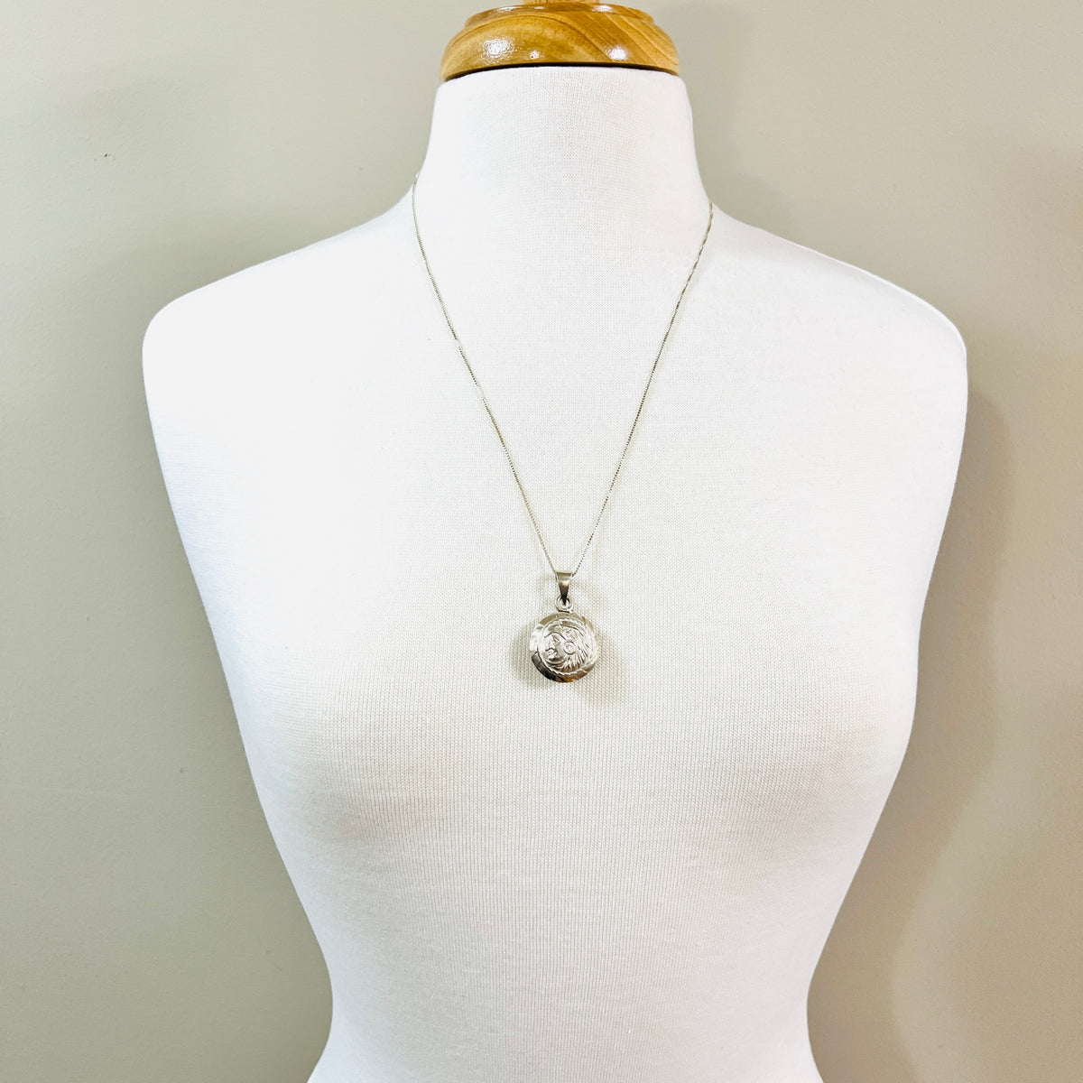 Vintage silver Aztec sun pendant necklace on 24-inch chain displayed on white bust