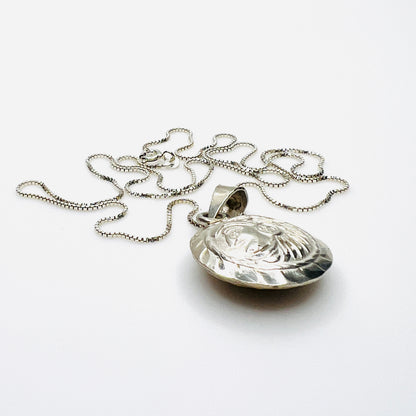 Side view of domed vintage silver Aztec pendant showing dimensional construction
