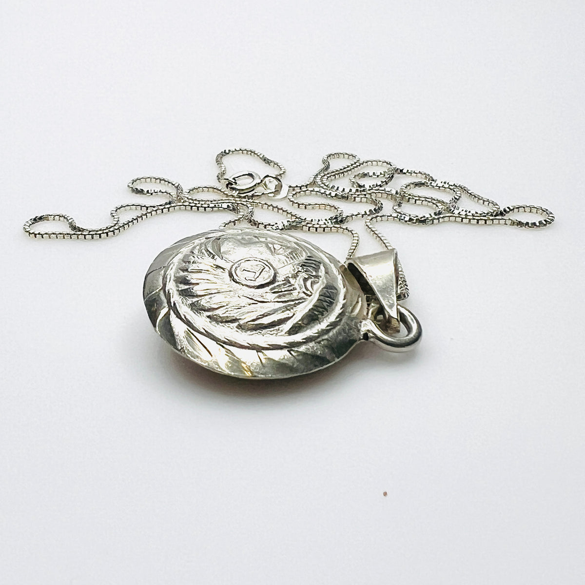 Side view of domed vintage silver Aztec pendant showing dimensional construction