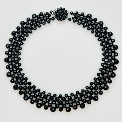 Top view of multi strand black beaded collar necklace