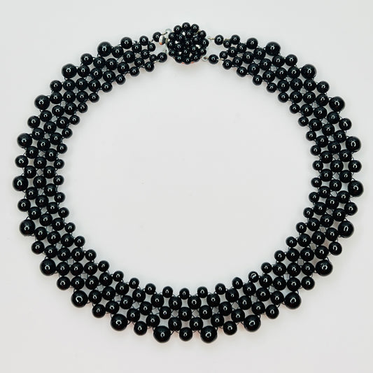 Top view of multi strand black beaded collar necklace