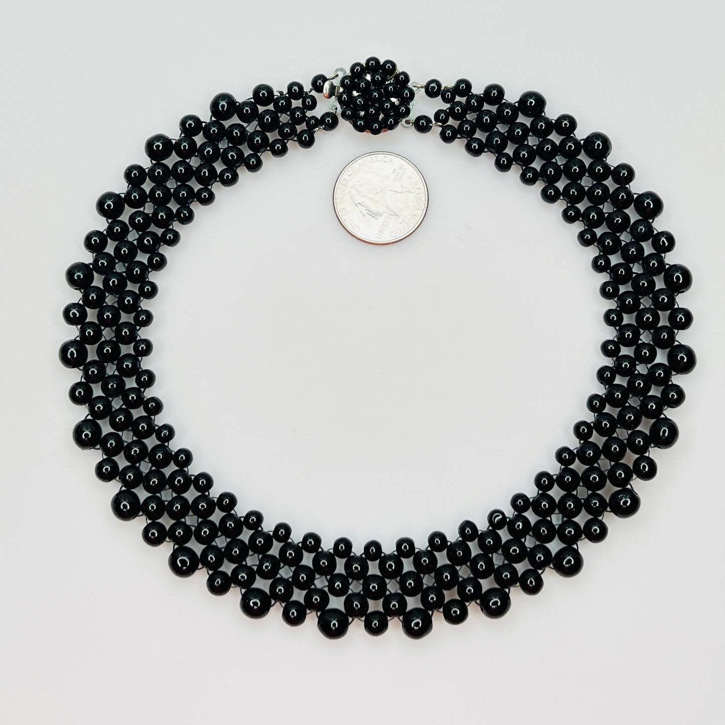 Top view of multi strand black beaded collar necklace