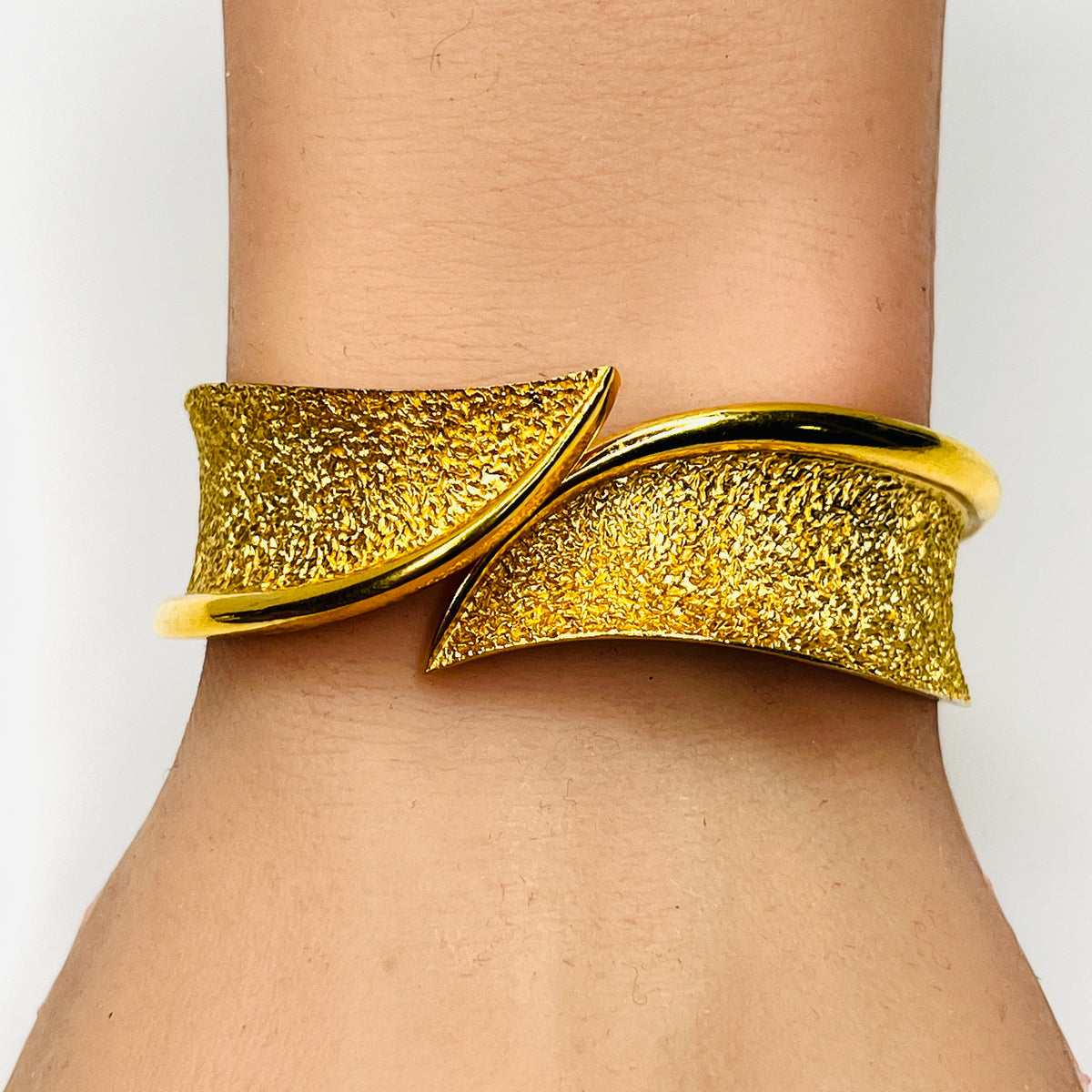 Crown Trifari gold tone bypass clamper bracelet shown worn on wrist