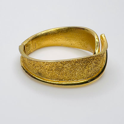 Vintage Trifari textured gold tone hinged bracelet with sweeping polished edge
