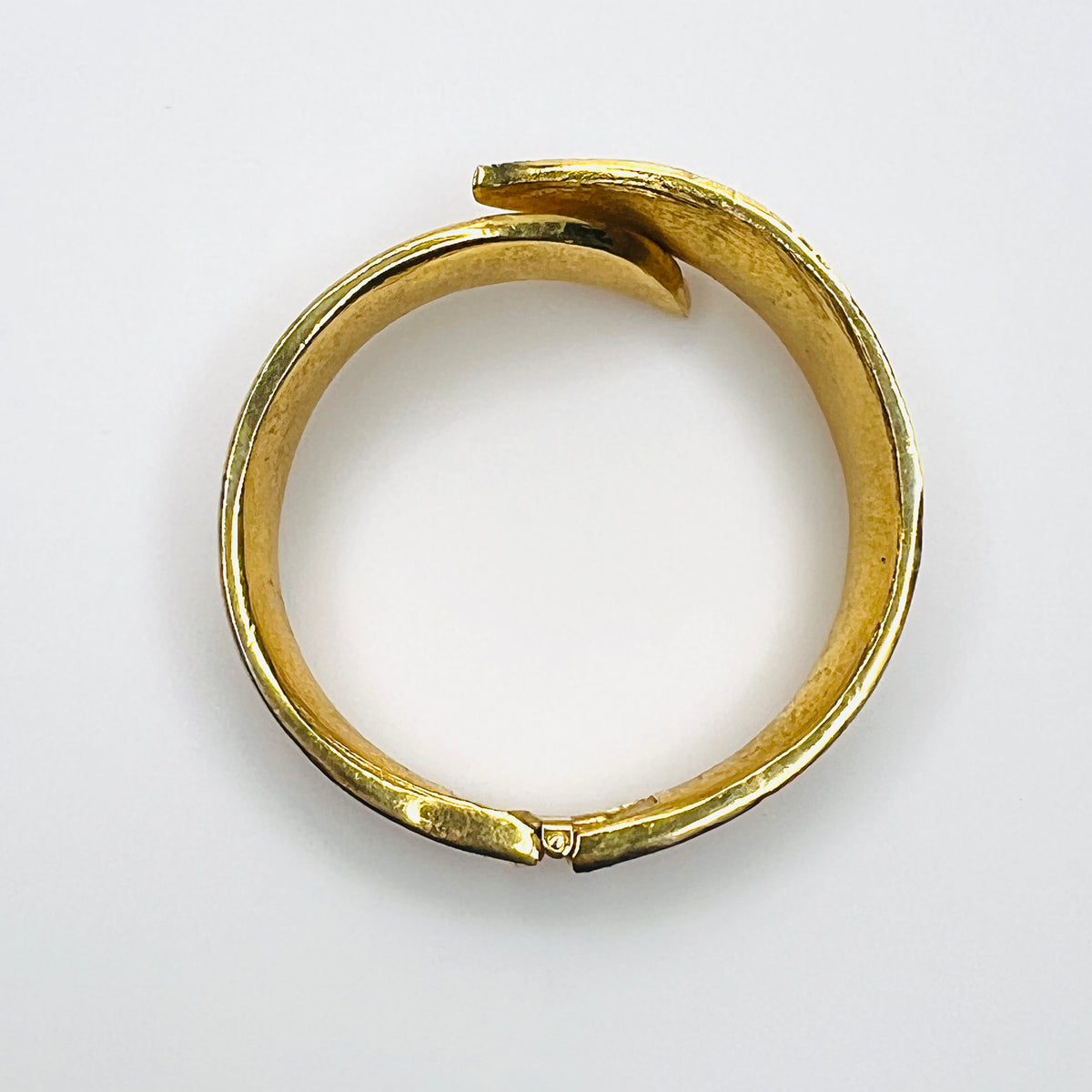 Top view of Vintage Trifari textured gold tone hinged bracelet with sweeping polished edge