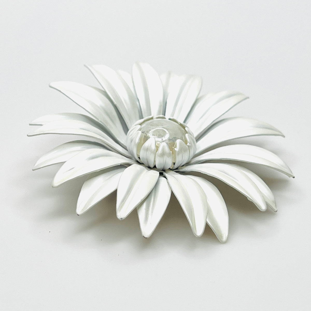 Side view of white enamel daisy brooch showing curved layered petals, Lucite center, and tiny enamel chips.