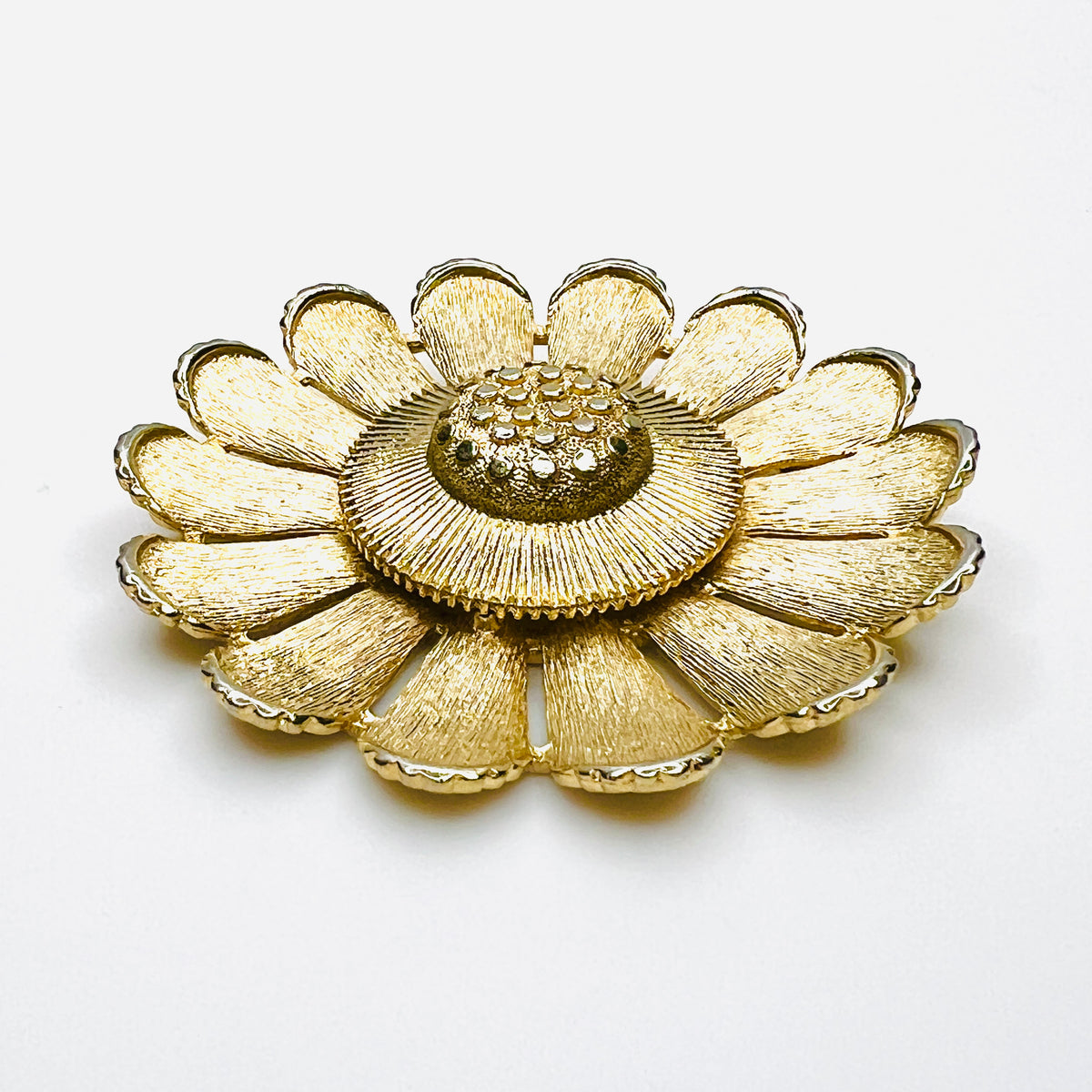 Side view of dimensional Sarah Coventry gold tone daisy flower brooch