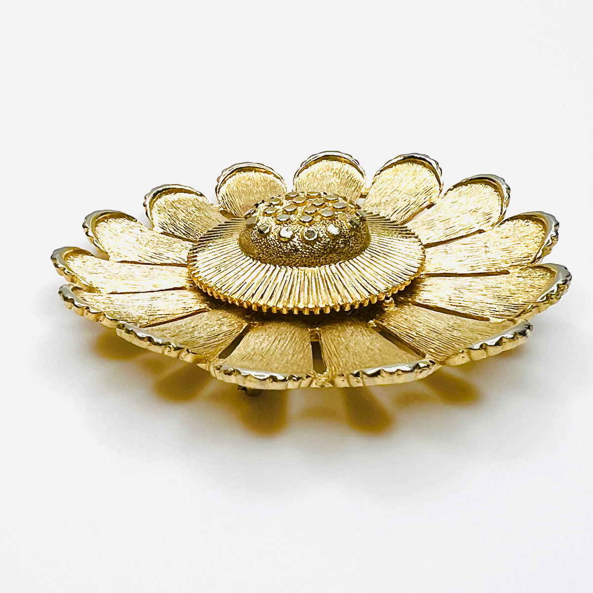 Side view of dimensional Sarah Coventry gold tone daisy flower brooch