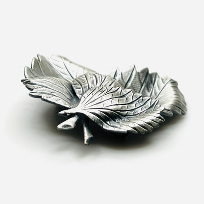 Side profile of vintage sculptural three leaf brooch in aged silver tone
