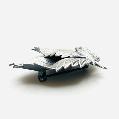 Side profile of vintage sculptural three leaf brooch in aged silver tone