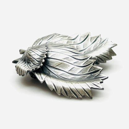 Side profile of vintage sculptural three leaf brooch in aged silver tone