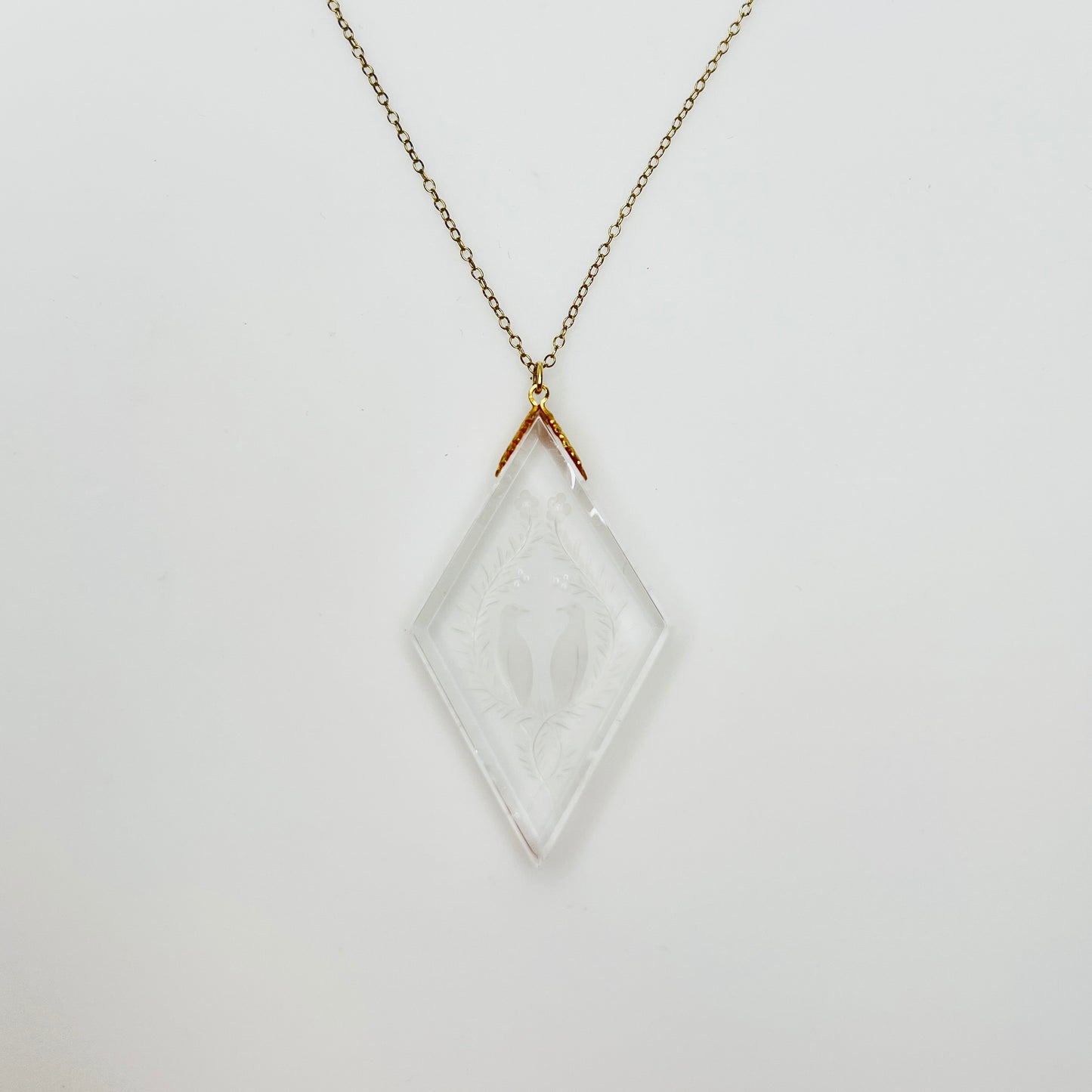 Necklace worn on mannequin showing large clear intaglio pendant