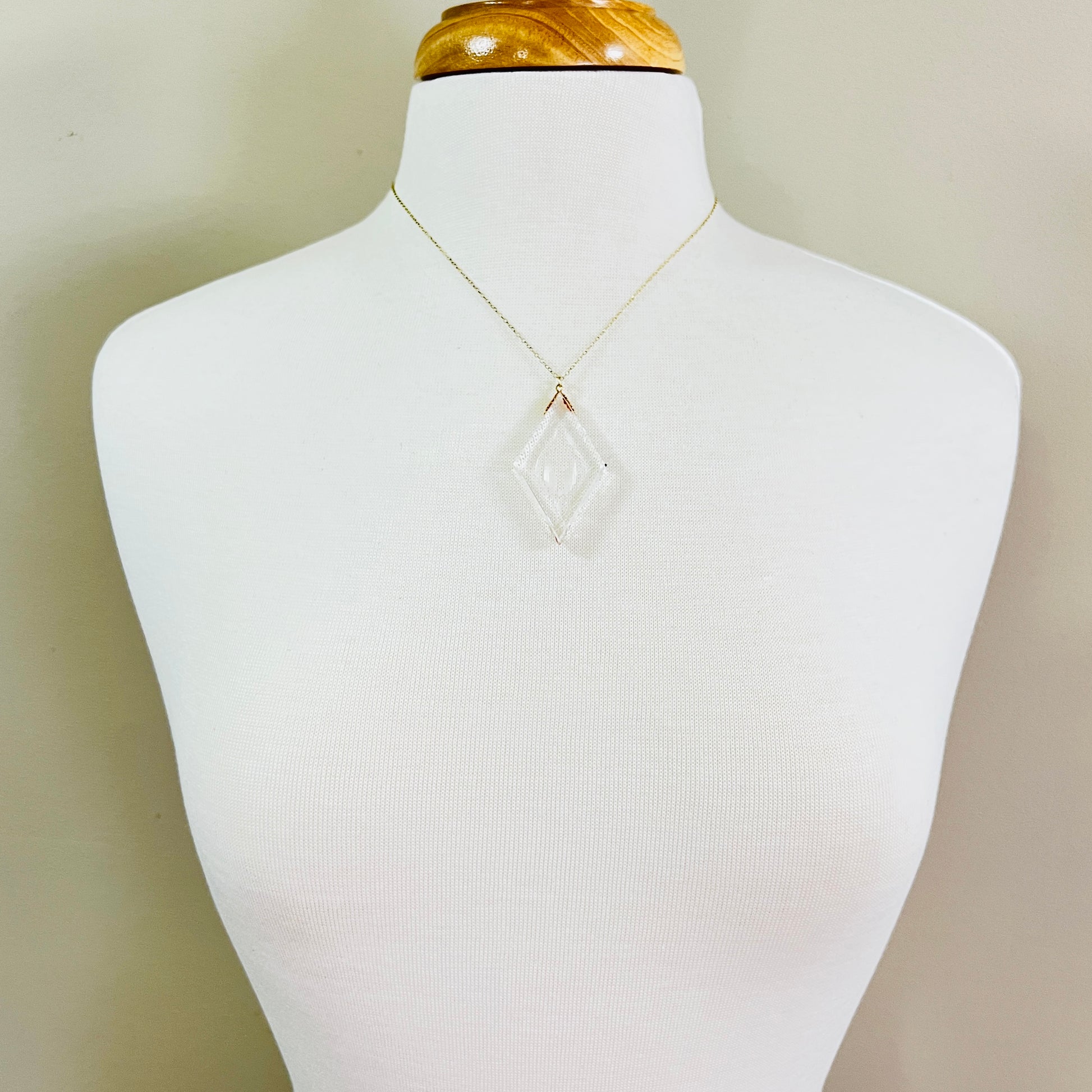Necklace worn on mannequin showing large clear intaglio pendant