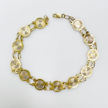 Reverse of vintage 14K gold saints bracelet showing concentric medal backs