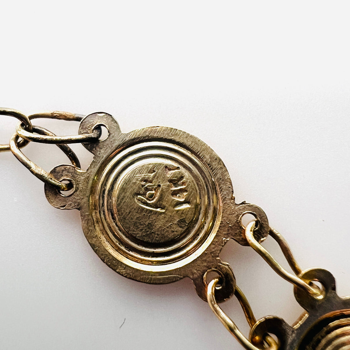 Close-up of maker's mark on vintage 14K gold Catholic medal bracelet