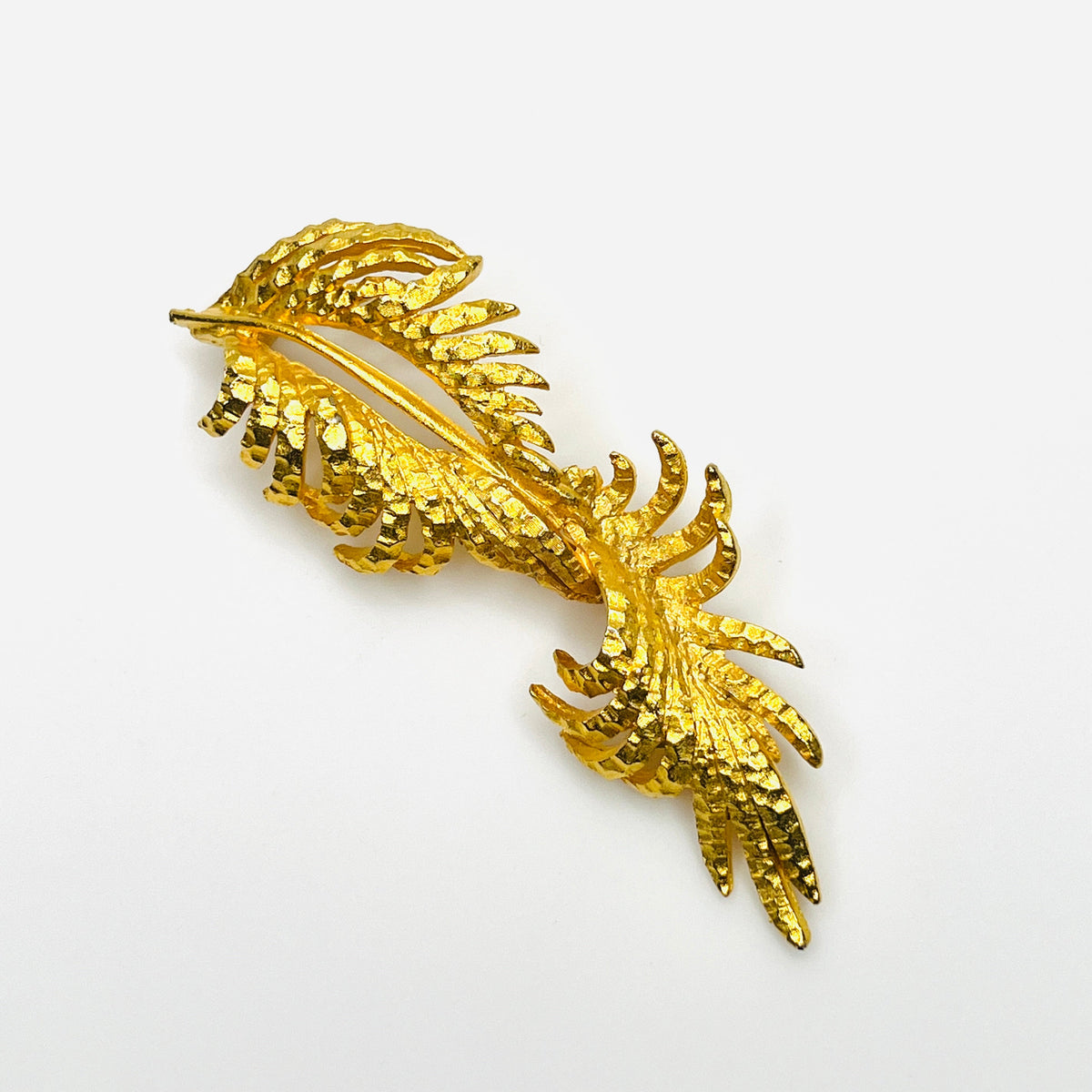 Vintage 1970s BSK gold-tone statement brooch featuring textured fern-like foliage and sweeping botanical design