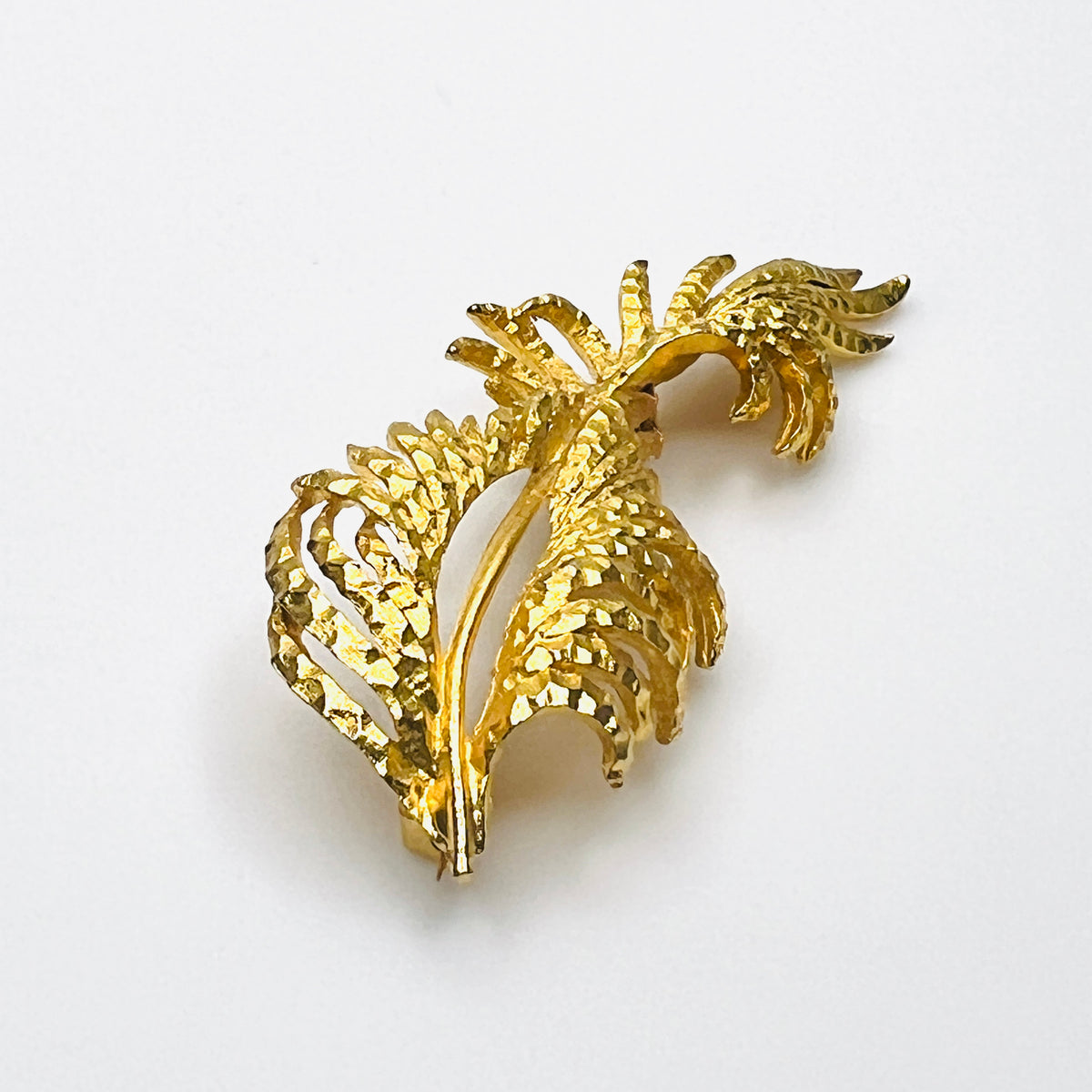 Side profile of vintage BSK botanical brooch showing dimensional textured gold-tone metal foliage