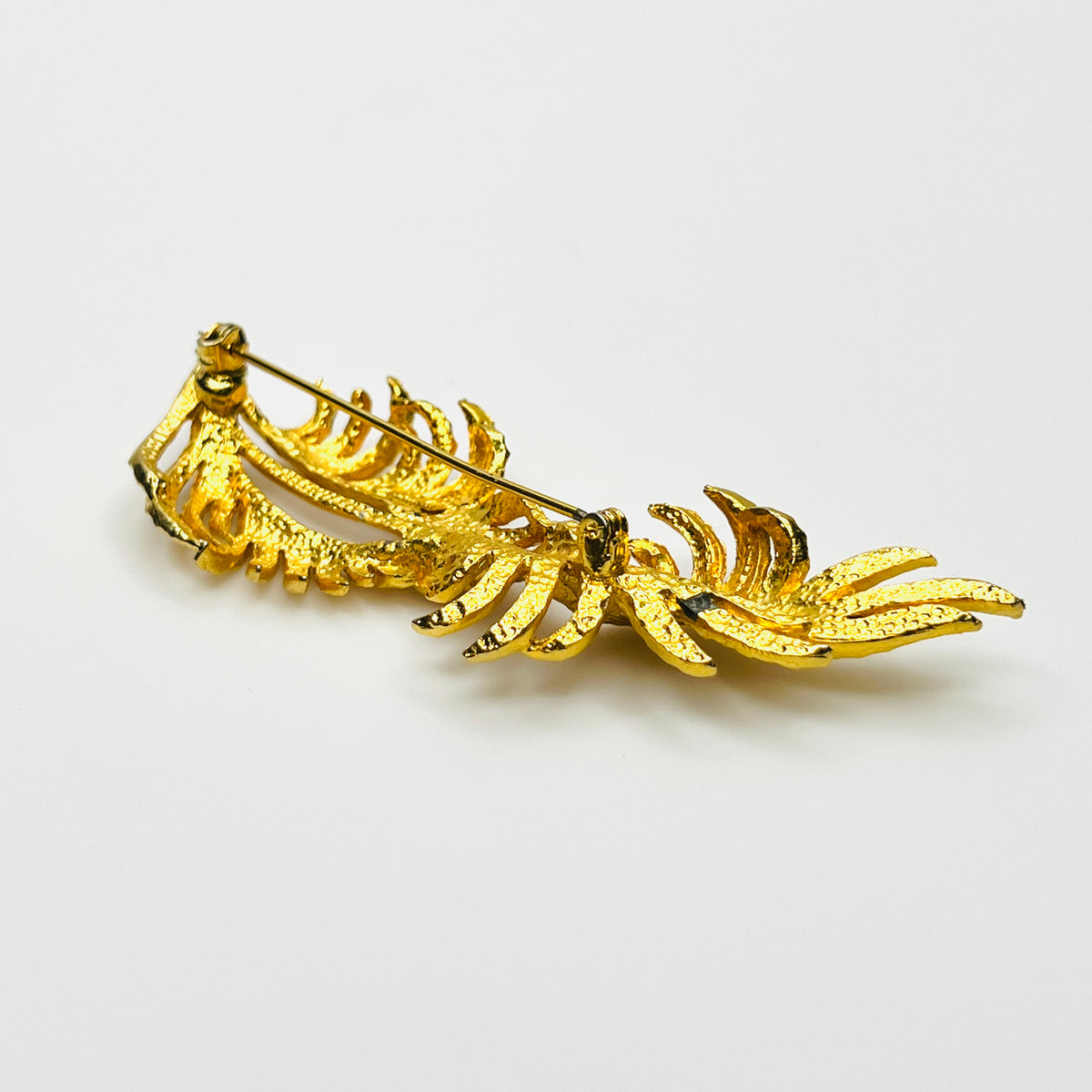 Side profile of vintage BSK botanical brooch showing dimensional textured gold-tone metal foliage