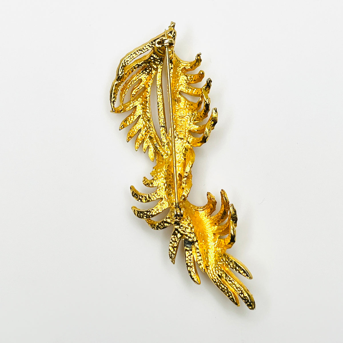 Reverse of vintage BSK gold-tone leaf spray brooch showing pin clasp and textured metal construction