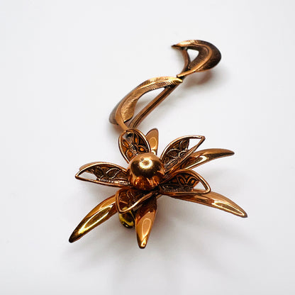 Side profile of vintage copper flower brooch showing raised petals and sculptural curved leaves