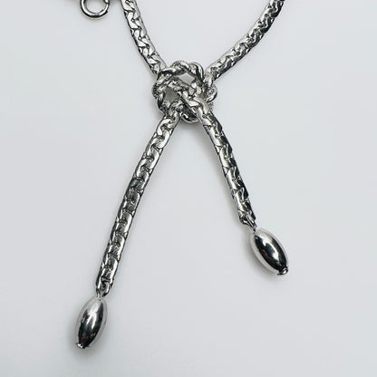 Close-up of knotted center and drop ends in silver tone