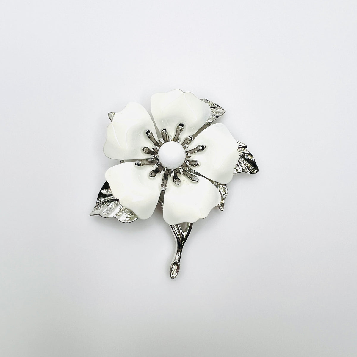Vintage 1970s Sarah Coventry white enamel flower brooch with silver-tone leaves and stem