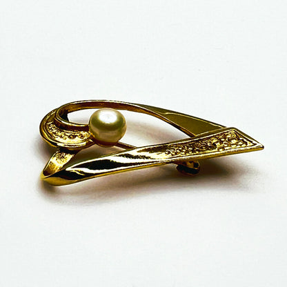 Side view of vintage sterling silver vermeil heart pin showing dimensional ribbon construction, textured detailing and raised pearl.