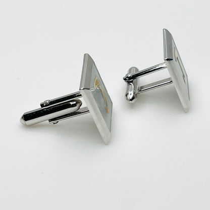 Side view of vintage Swank cufflinks showing silver tone swivel bar closures