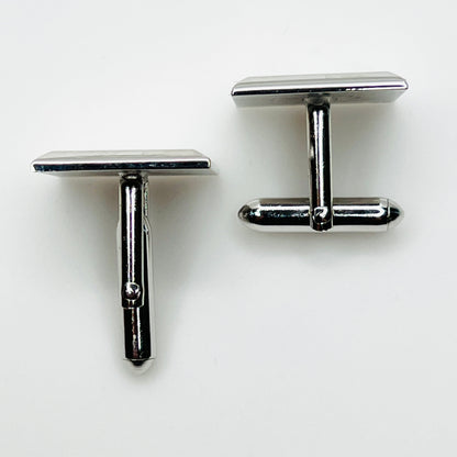 Top view of vintage Swank cufflinks showing silver tone swivel bar closures