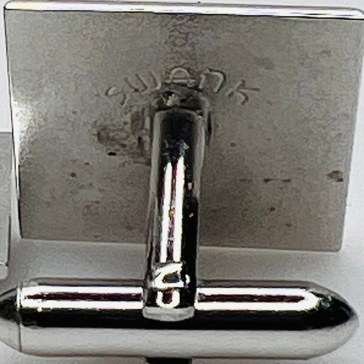 Close-up of Swank maker signature stamped on reverse of vintage cufflink