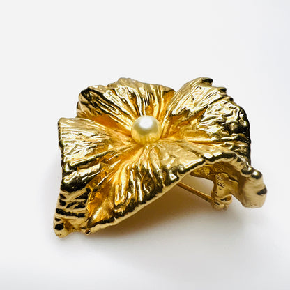 Angled side view of vintage Napier brooch showing deeply sculpted gold-tone folds, dimensional construction, and faux pearl center.