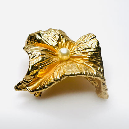 Angled side view of vintage Napier brooch showing deeply sculpted gold-tone folds, dimensional construction, and faux pearl center.