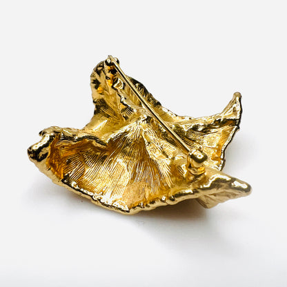Angled reverse side view of vintage Napier brooch showing deeply sculpted gold-tone folds, dimensional construction, and faux pearl center.