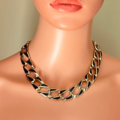 Vintage oversized gold and black enamel chain necklace displayed on mannequin.
