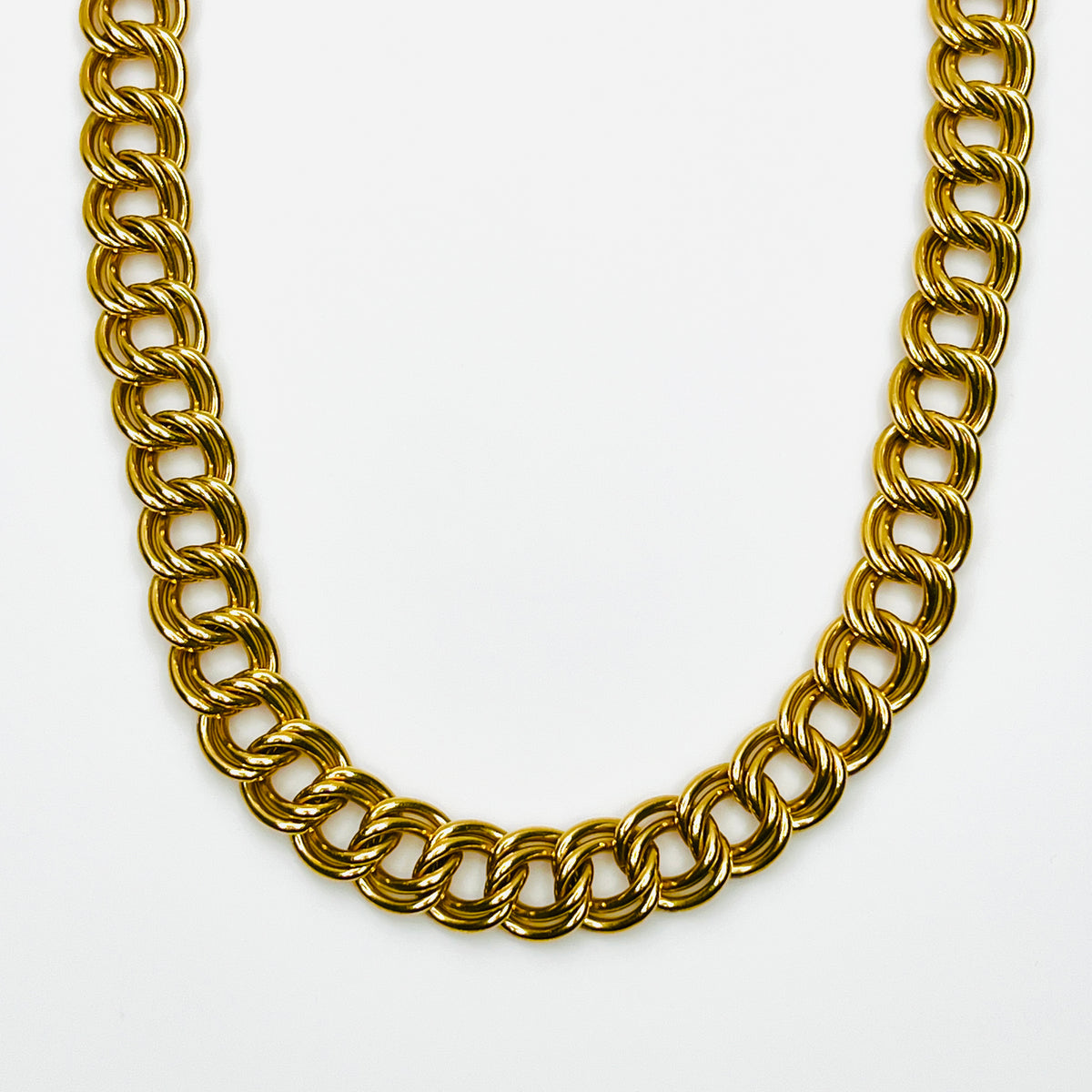 Close-up of vintage 1980s chunky gold-tone necklace featuring polished, dimensional double-link chain construction.