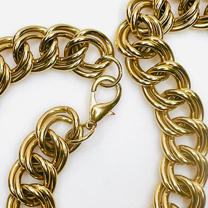 Detailed close-up of large gold-tone lobster claw clasp and interlocking double-link construction on vintage statement necklace.