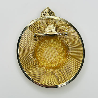 Reverse of 1980s gold mesh hat brooch showing woven metal construction and rollover safety clasp