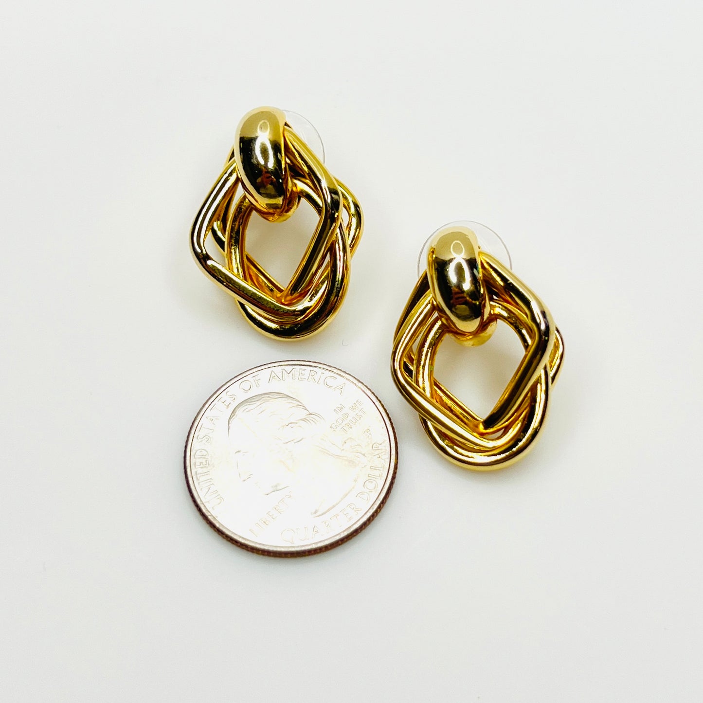 Vintage gold tone geometric earrings with quarter for size reference