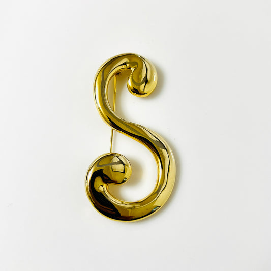 Vintage 1980s oversized gold-tone letter S brooch with polished rounded curves and curled script ends.