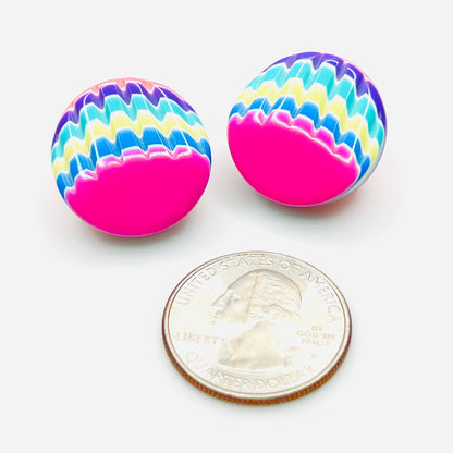 Neon pink and multicolor resin stud earrings beside quarter for scale