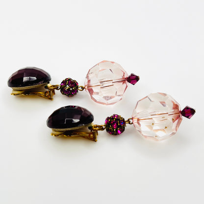 side view of vintage 1980s acrylic clip-on earrings with faceted pink beads and gold-tone hardware.