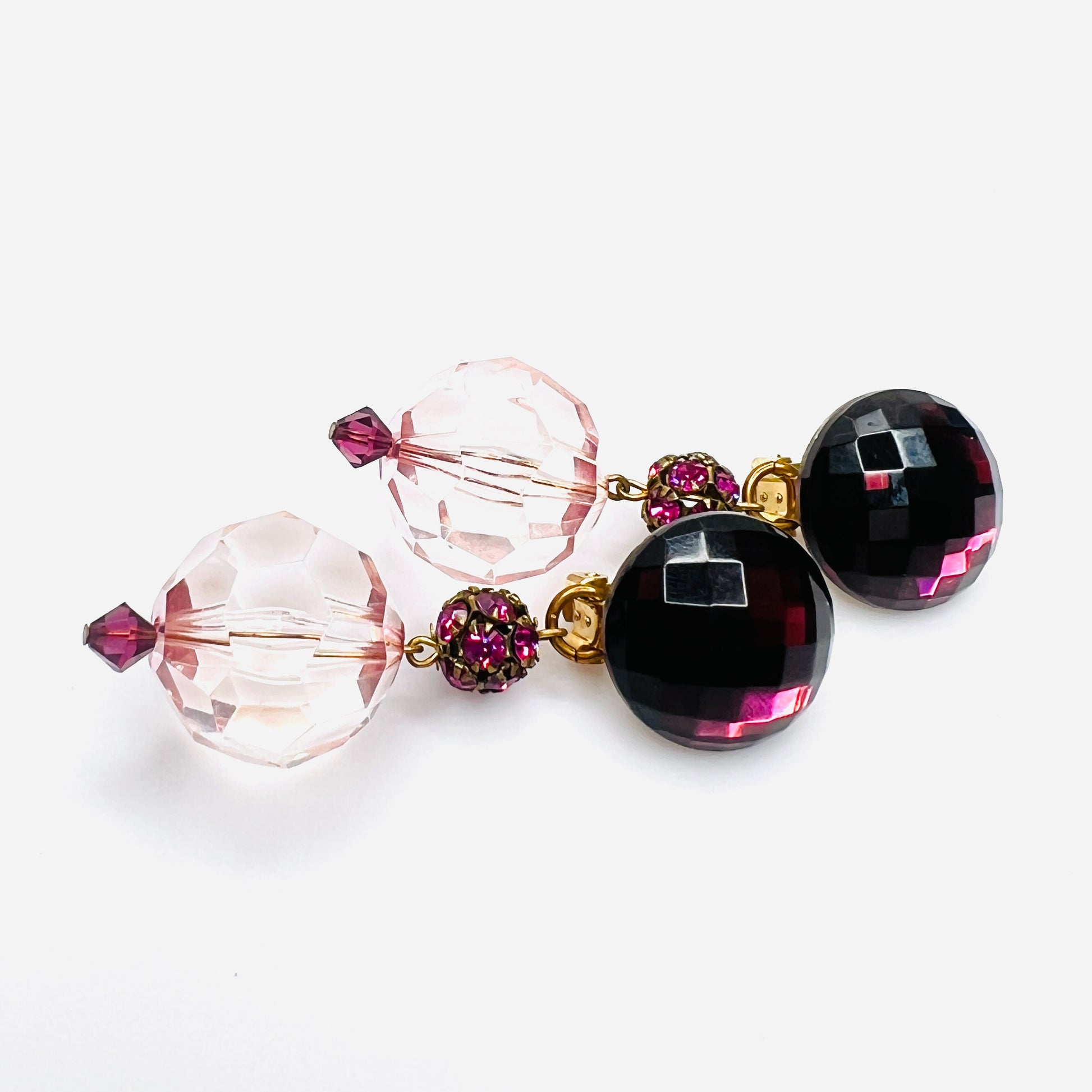 side view of vintage 1980s acrylic clip-on earrings with faceted pink beads and gold-tone hardware.