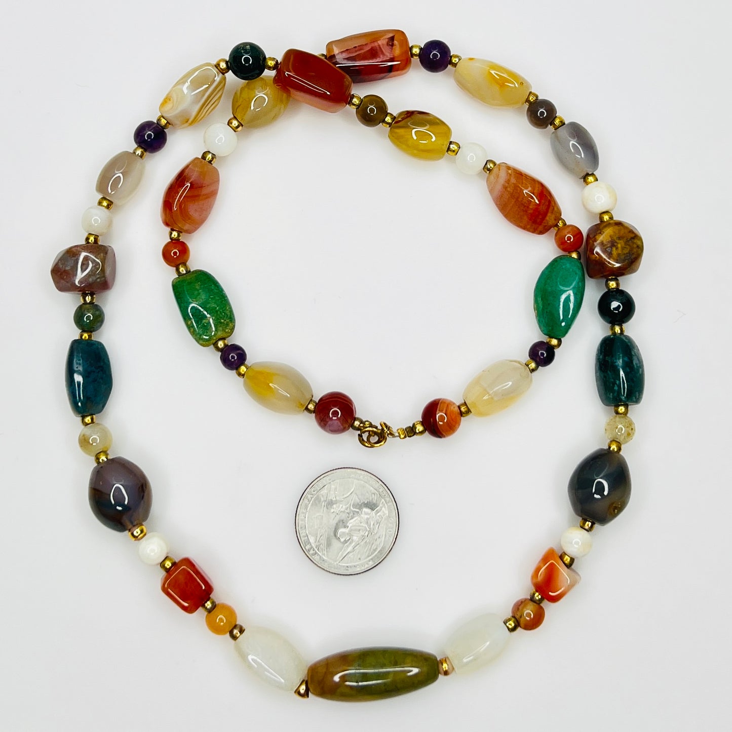 Close up of multicolor polished gemstone beads with gold spacers