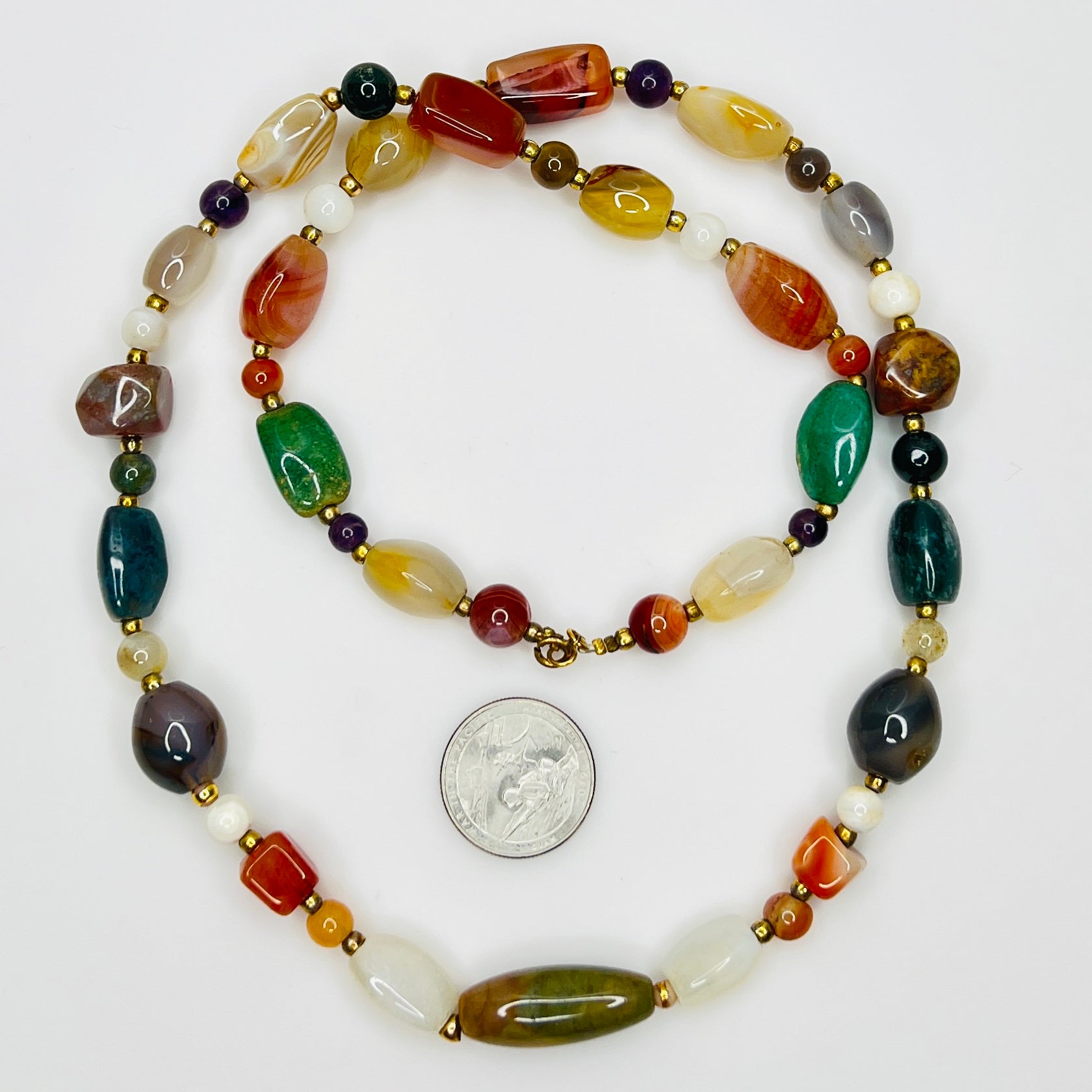 Close up of multicolor polished gemstone beads with gold spacers