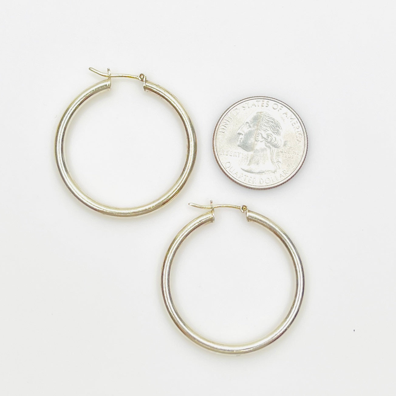 Sterling silver hoop earrings stamped 925 Italy shown with quarter for scale