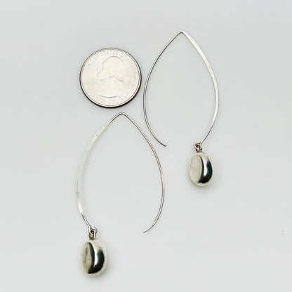 Sterling silver modernist drop earrings beside quarter for size comparison