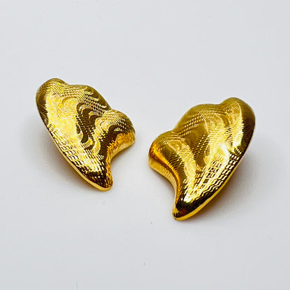 Side view of vintage 1980s gold tone pierced statement earrings
